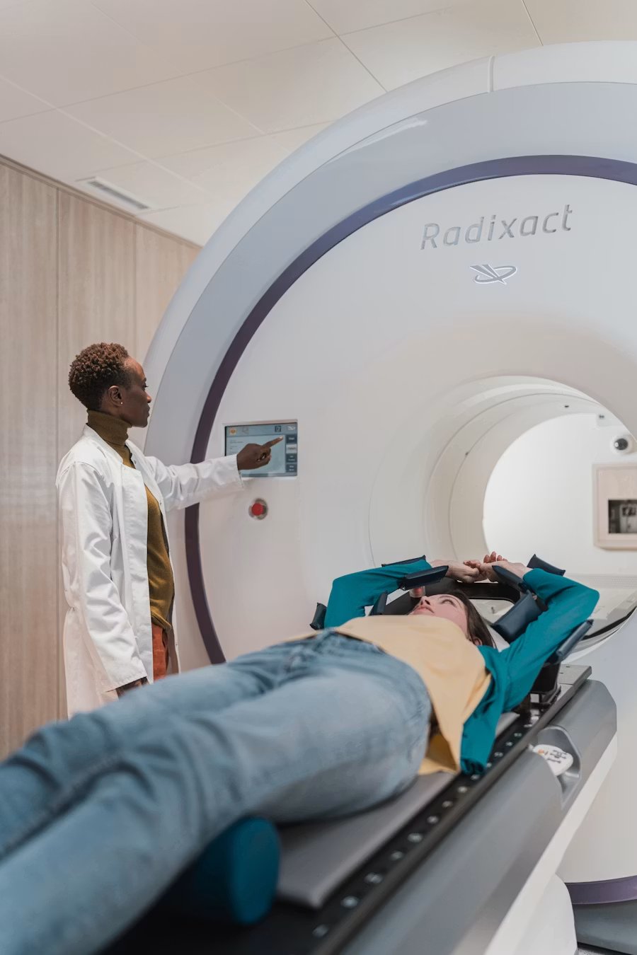 A clinician guiding a patient through an advanced imaging and treatment system